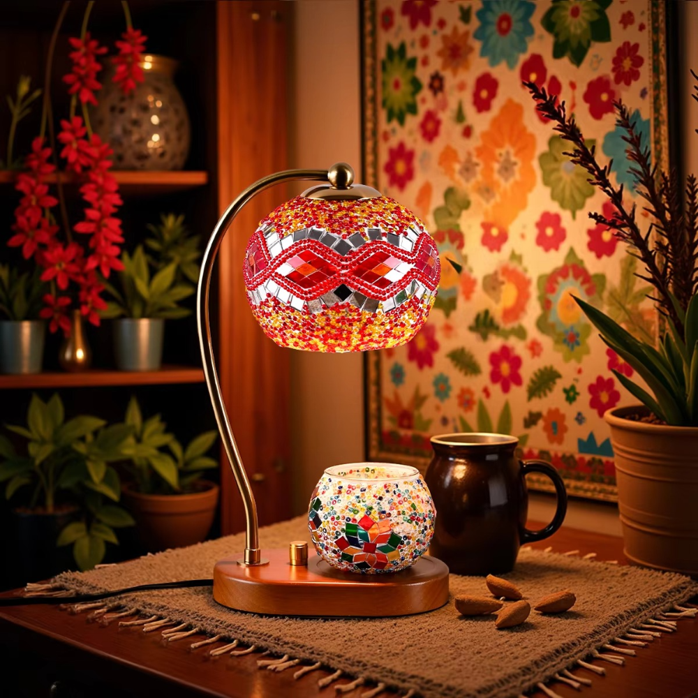 Decorative table lamp with mosaic design on a wooden surface, surrounded by plants and a colorful wall.